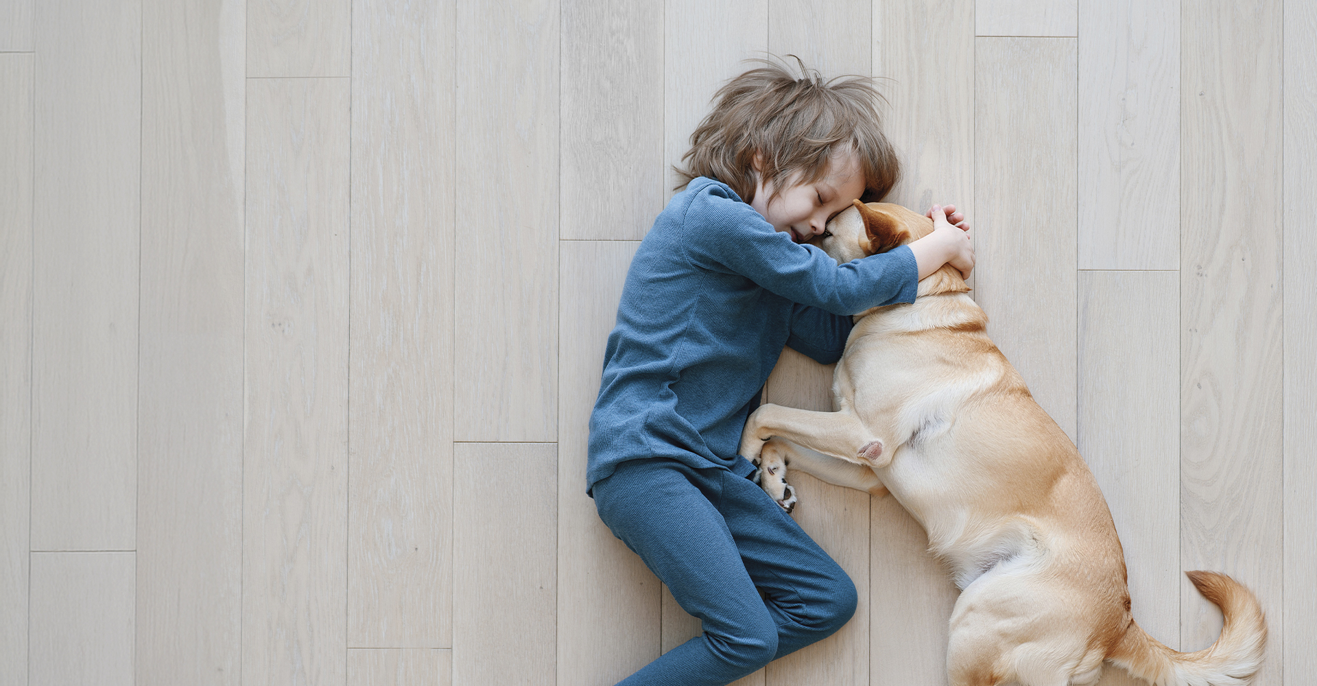 Child laying on Luxury Vinyl Floor with Dog.